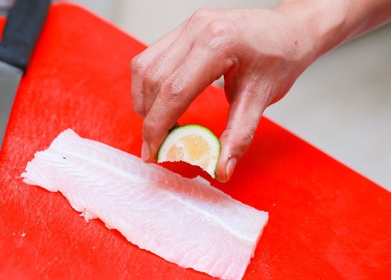Поместим в емкость рыбу и сбрызнем лимонным соком