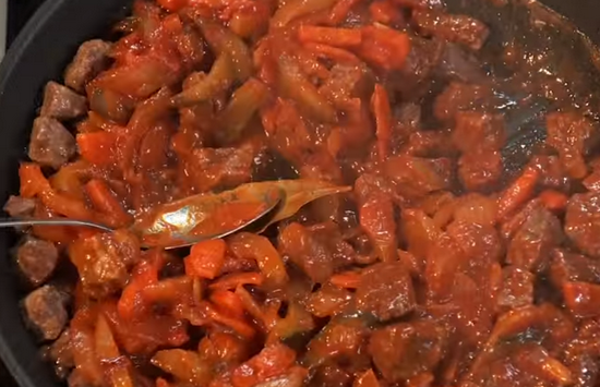 Мясо, лук и помидорное пюре при постоянном помешивании готовьте 5 минут