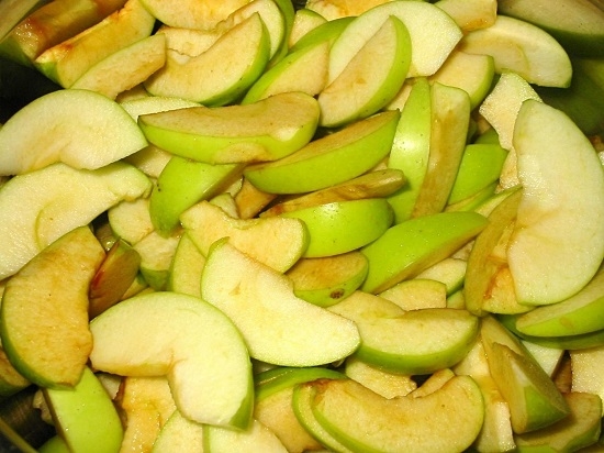 Измельчаем яблоки дольками и выкладываем в глубокую кастрюлю