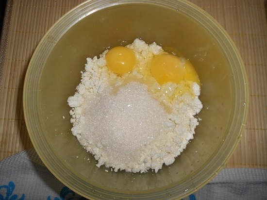 Добавляем в творог яйца и сахарный песок