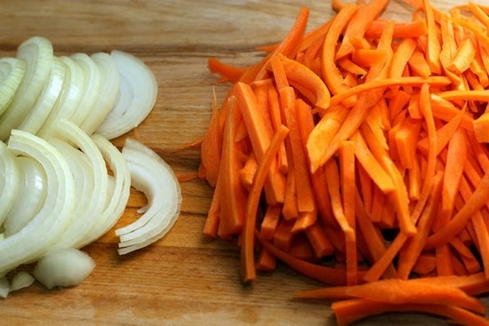 Крупно натрите морковь и нашинкуйте лук