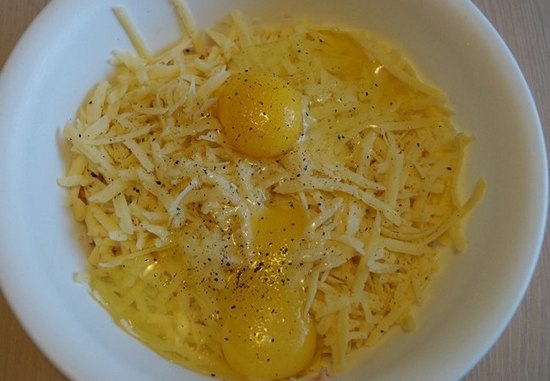 Сыр измельчите с помощью крупной терки и смешайте с яйцом.