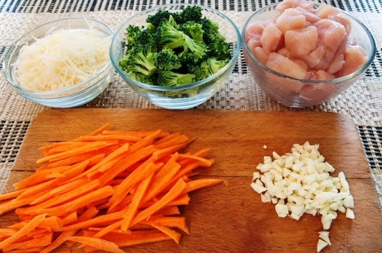 Подготовим ингредиенты. Сыр натрем на мелкой терке, брокколи разберем на соцветия, а морковь и чесночные зубчики очистим и нарежем