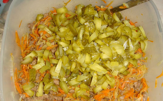 Маринованные огурчики нарезаем соломкой и добавляем в салат