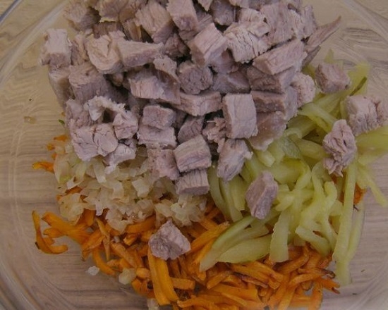 В салатнице соединяем мясо, огурчики, лук и морковь
